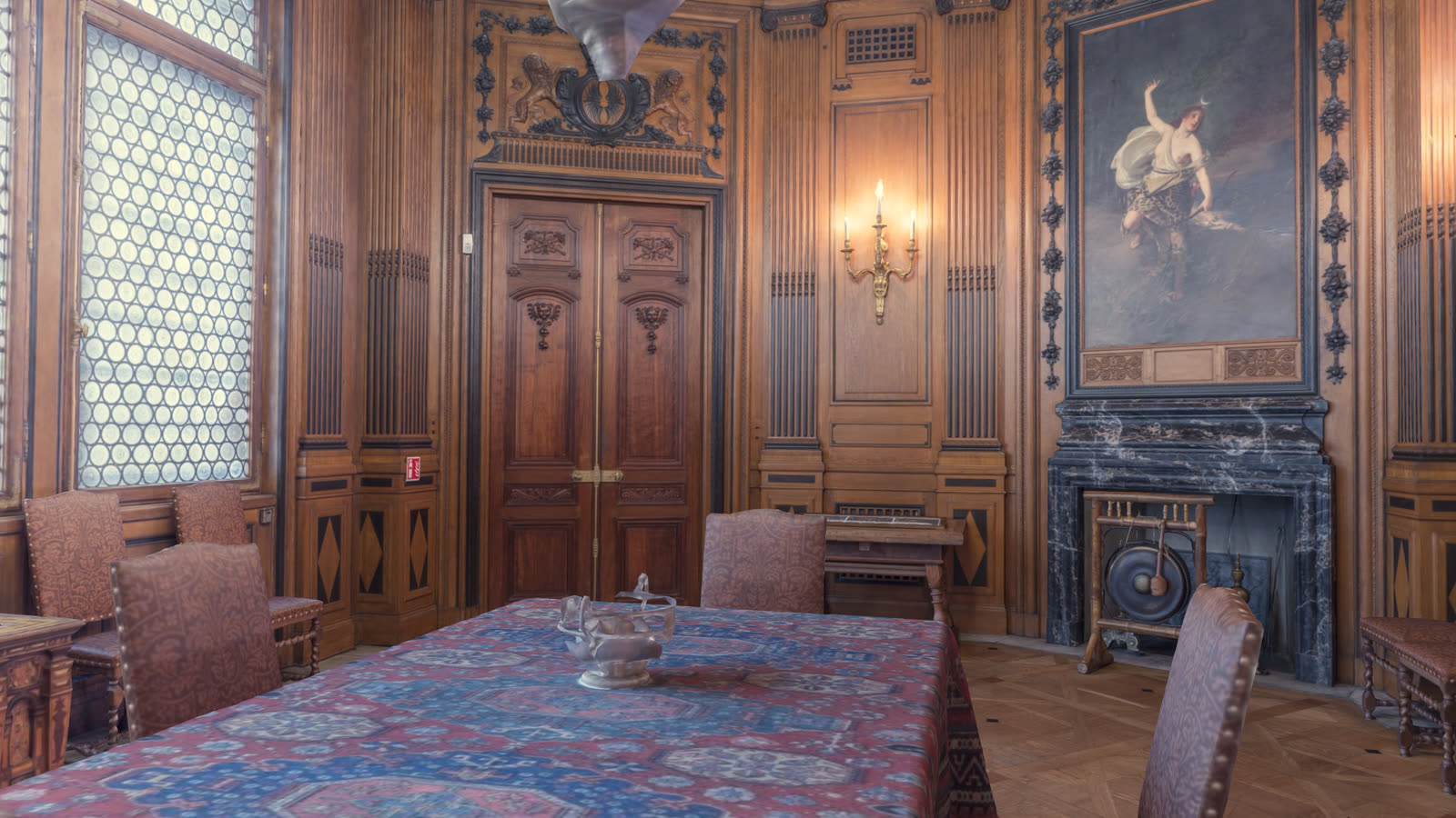 The Dining Room: oak panelling with black bog-oak details, a covered table and high leaded windows